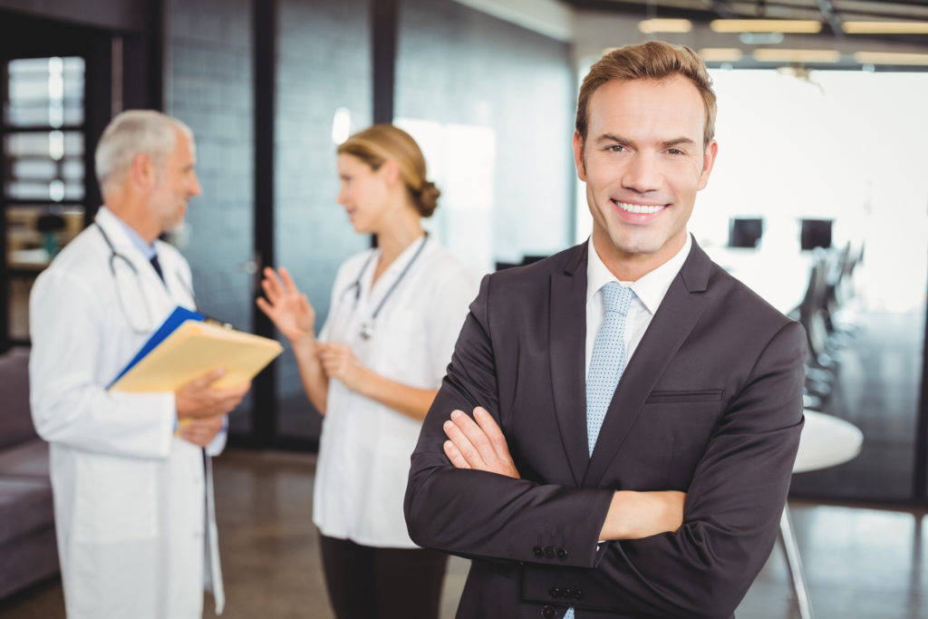 healthcare business professional with blurred medical colleagues consulting in the background